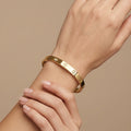 Bracelet jonc vis en or jaune 18k serti de pierres - bijou porté par une mannequin