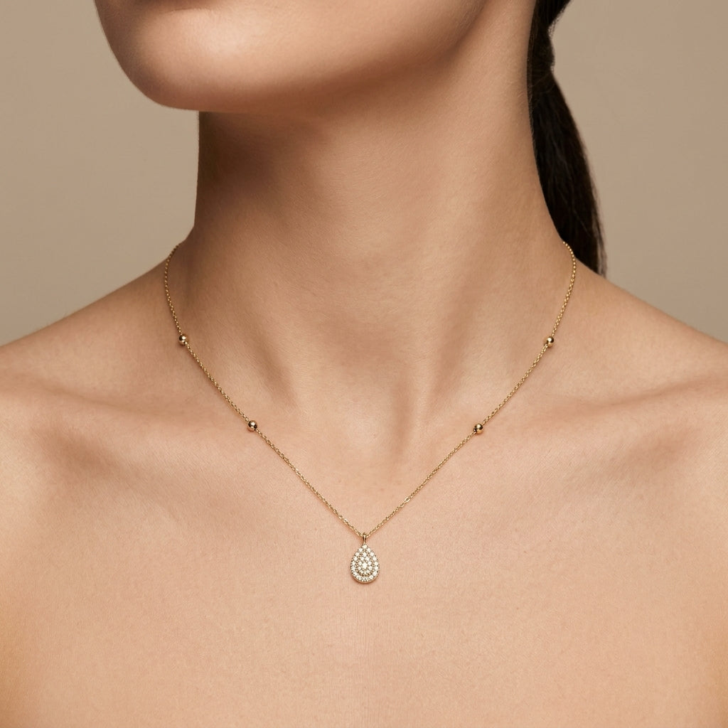 Collier en or jaune 18k pendentif goutte serti de pierres - bijou porté par une mannequin
