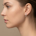 Boucles d'oreilles puces en or jaune 18k serties de pierres - bijou porté par une mannequin
