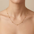 Chaîne fine en or jaune 18k à petites boules - bijou porté par une mannequin