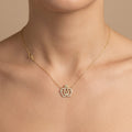 Collier en or jaune 18k pendentif couronne serti de pierres - bijou porté par une mannequin