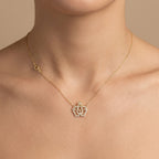 Collier en or jaune 18k pendentif couronne serti de pierres - bijou porté par une mannequin