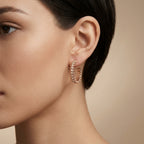 Boucles d'oreilles créoles en or rose 18k serties, motif clash - bijou porté par une mannequin