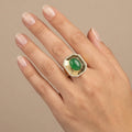 Bague en or jaune 18k pierre verte ovale entourage serti - bijou porté par une mannequin
