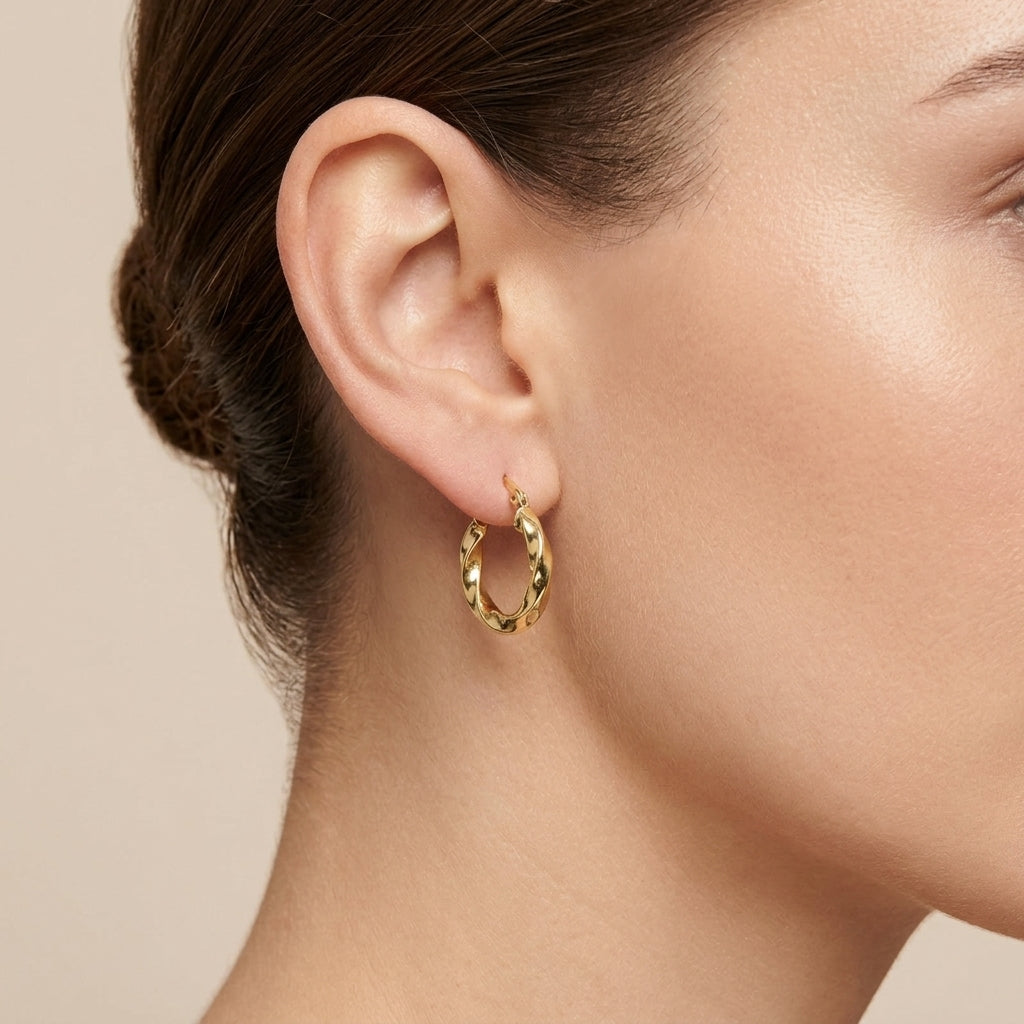 Boucles d'oreilles créoles torsadées en or jaune 18k - bijou porté par une mannequin