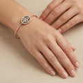 Bracelet jonc ouvert fleur de lys en or rose 18k serti de pierres - bijou porté par une mannequin
