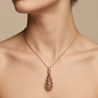 Pendentif goutte ajourée et ciselée en or rose 18k sertie de pierres - bijou porté par une mannequin
