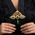 Broche beldi ajourée en or jaune 18k sertie de pierres vertes et blanches, pampille - bijou porté par une mannequin