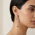 Boucles d'oreilles pendantes beldi ajourées en or rose 18k serties de pierres vertes synthétiques - bijou porté par une mannequin