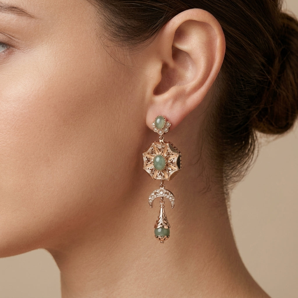 Boucles d'oreilles pendantes beldi rosaces en or rose 18k croissants et pierres vertes synthétiques - bijou porté par une mannequin