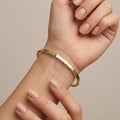 Bracelet jonc fin en or jaune 18k pastilles rondes - bijou porté par une mannequin