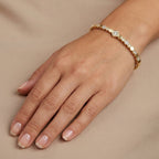 Bracelet jonc fin en or jaune 18k pastilles rondes serti d'une pierre - bijou porté par une mannequin