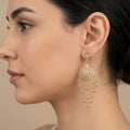 Boucles d'oreilles pendantes beldi rosaces ajourées en or 18k à franges - bijou porté par une mannequin