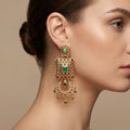 Boucles d'oreilles pendantes beldi en or rose 18k serties de pierres, pierres vertes synthétiques - bijou porté par une mannequin