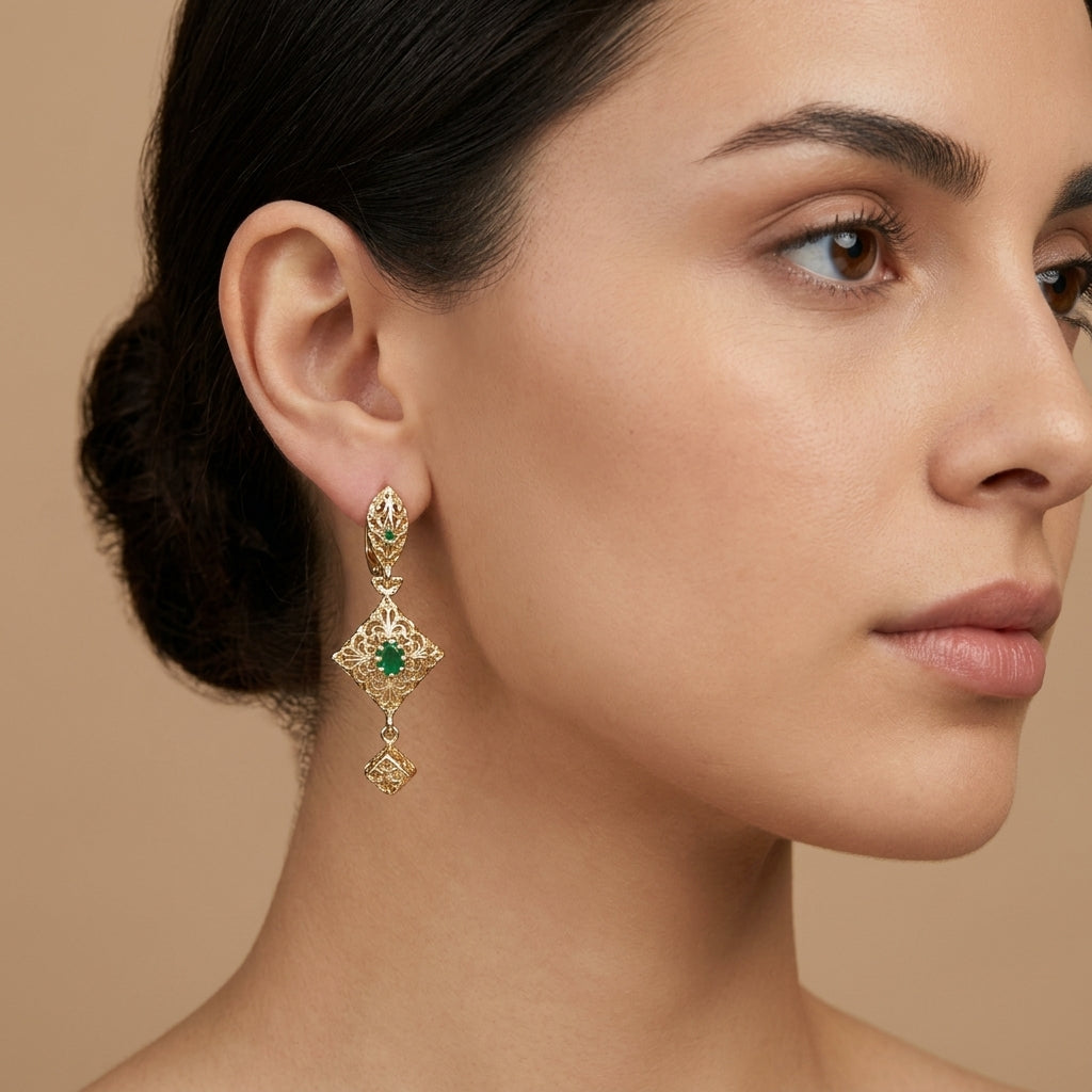Boucles d'oreilles pendantes beldi en or jaune 18k serties de pierres, pierre verte - bijou porté par une mannequin