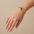 Bracelet jonc beldi ajouré en or jaune 18k serti de pierres, pierre verte - bijou porté par une mannequin