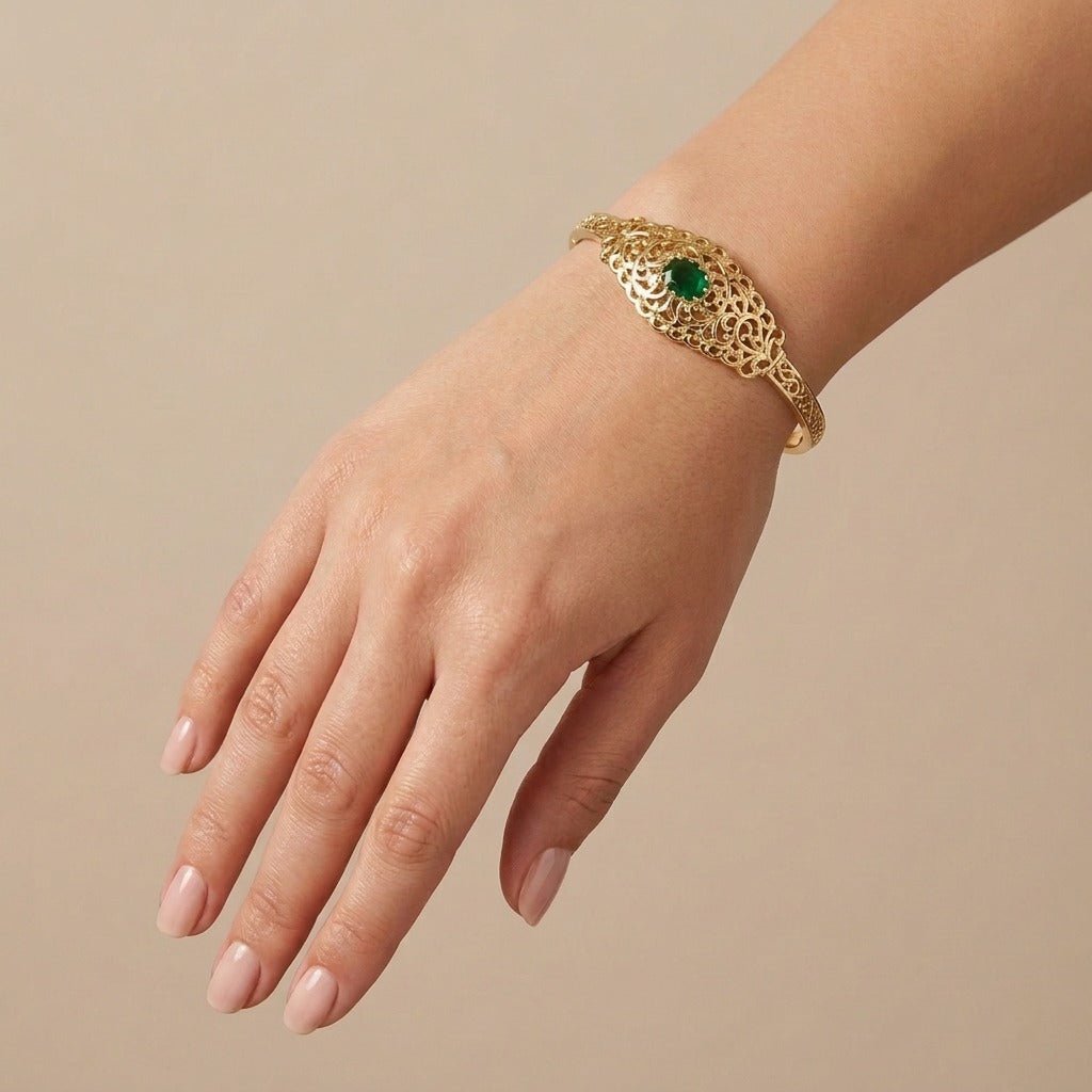 Bracelet jonc beldi ajouré en or jaune 18k serti de pierres, pierre verte - bijou porté par une mannequin