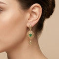 Boucles d'oreilles pendantes beldi rosaces en or jaune 18k serties, pierre verte - bijou porté par une mannequin