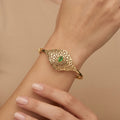 Bracelet jonc beldi ajouré losange en or jaune 18k serti de pierres, pierre verte - bijou porté par une mannequin