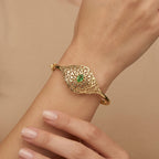 Bracelet jonc beldi ajouré losange en or jaune 18k serti de pierres, pierre verte - bijou porté par une mannequin