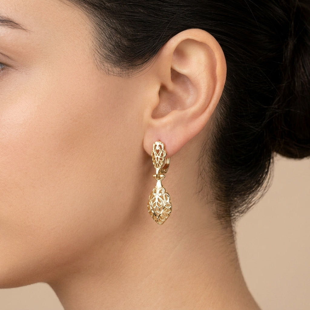 Boucles d'oreilles pendantes beldi ajourées et ciselées en or jaune 18k - bijou porté par une mannequin