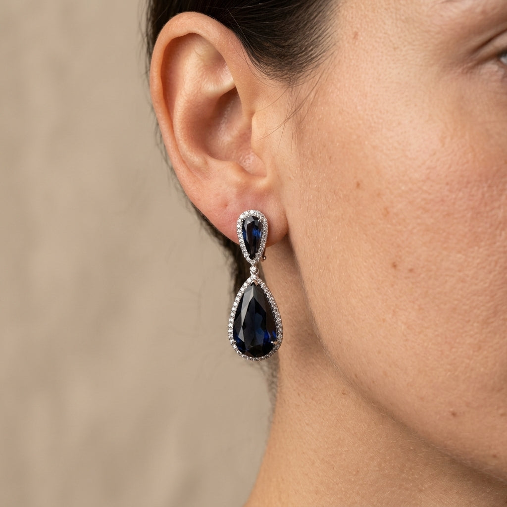 Boucles d'oreilles pendantes gouttes pierres bleues en or blanc 18k serties - bijou porté par une mannequin