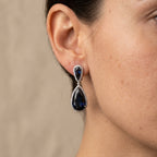 Boucles d'oreilles pendantes gouttes pierres bleues en or blanc 18k serties - bijou porté par une mannequin