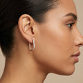 Boucles d'oreilles créoles carrées en or rose 18k serties de pierres - bijou porté par une mannequin