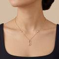 Collier en or jaune 18k pendentif épingle serti de pierres - bijou porté par une mannequin