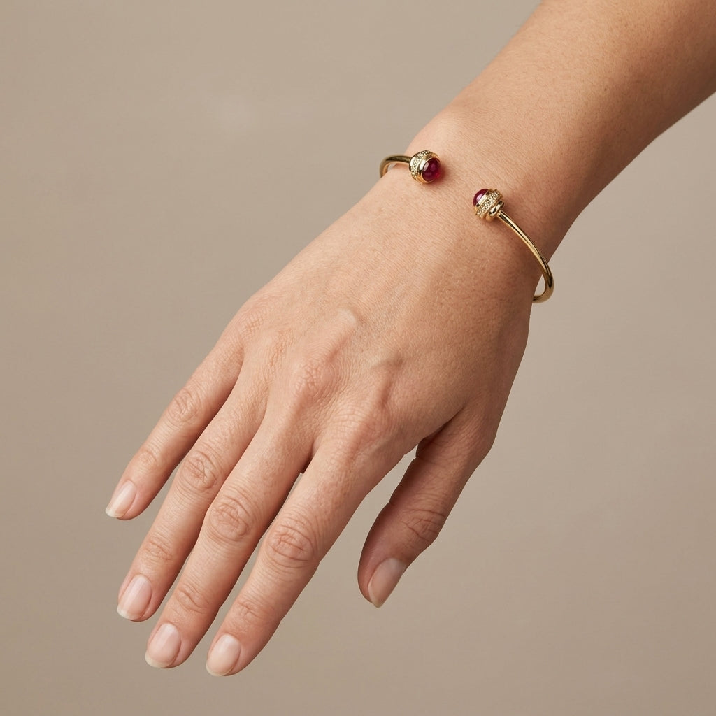 Bracelet jonc ouvert en or jaune 18k pierres rouges cabochon - bijou porté par une mannequin