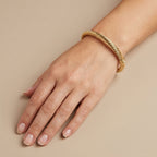 Bracelet jonc torsadé en or jaune 18k - bijou porté par une mannequin