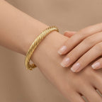 Bracelet jonc torsadé en or jaune 18k - bijou porté par une mannequin