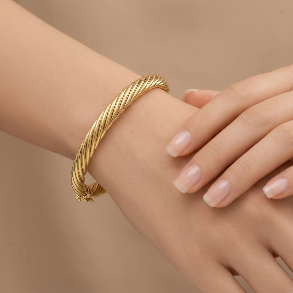 Bracelet jonc torsadé en or jaune 18k - bijou porté par une mannequin