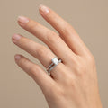 Bague solitaire pierre rectangulaire en or blanc 18k double anneau serti - bijou porté par une mannequin