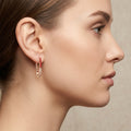 Boucles d'oreilles pendantes en or rose 18k serties, émail rouge - bijou porté par une mannequin