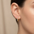 Boucles d'oreilles mini créoles en or jaune 18k serties de pierres - bijou porté par une mannequin