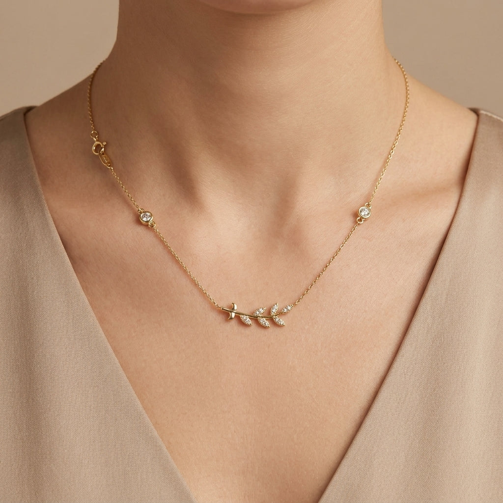 Collier en or jaune 18k pendentif branche feuilles sertie - bijou porté par une mannequin