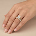 Bague solitaire en or jaune 18k épaulée de pierres, double anneau - bijou porté par une mannequin