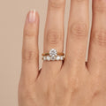 Bague solitaire en or jaune 18k épaulée de pierres, double anneau - bijou porté par une mannequin