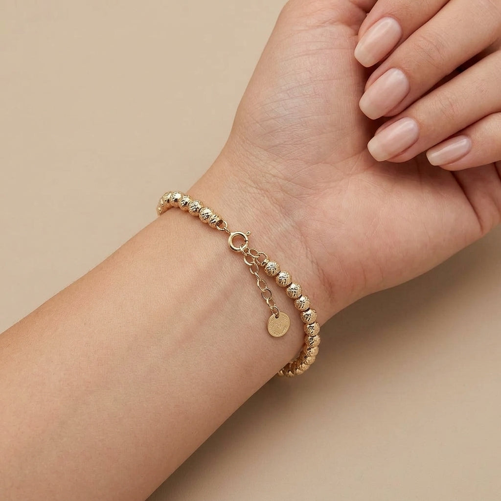 Bracelet boules facettées en or jaune 18k - bijou porté par une mannequin
