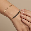 Bracelet chaîne en or jaune 18k boules noires facettées - bijou porté par une mannequin