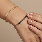 Bracelet chaîne en or jaune 18k boules noires facettées - bijou porté par une mannequin