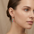 Boucles d'oreilles pendantes en or jaune 18k breloques émaillées bleu et rose - bijou porté par une mannequin