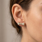 Boucles d'oreilles nœuds en or jaune 18k pavées de pierres - bijou porté par une mannequin