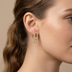 Boucles d'oreilles pendantes en or jaune 18k ovales sertis, pierre mobile - bijou porté par une mannequin