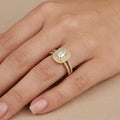 Bague solitaire pierre rectangulaire halo en or jaune 18k anneau serti - bijou porté par une mannequin