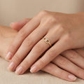 Bague fine en or jaune 18k sertie de pierres - bijou porté par une mannequin