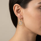 Boucles d'oreilles pendantes cercles en or rose 18k sertis de pierres blanches - bijou porté par une mannequin