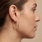 Boucles d'oreilles créoles fines en or rose 18k - bijou porté par une mannequin