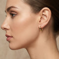 Boucles d'oreilles mini créoles bébé en or jaune 18k - bijou porté par une mannequin